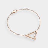 Rose gold bracelet with a triangle design on a light gray background