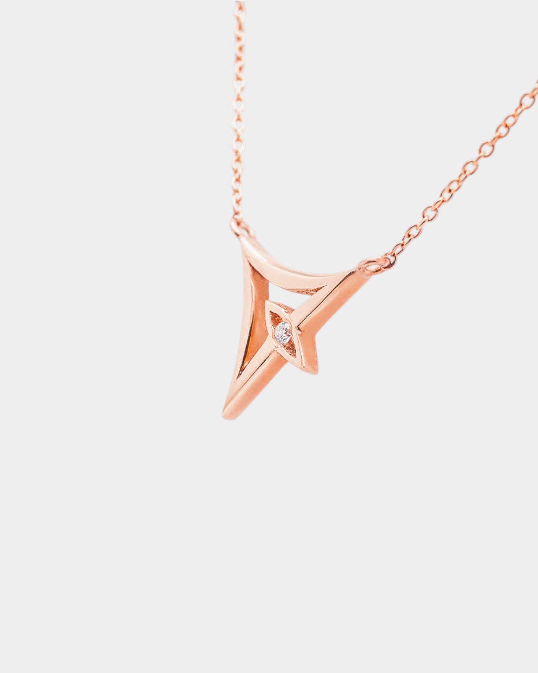 Rose gold necklace with a geometric pendant on a white background