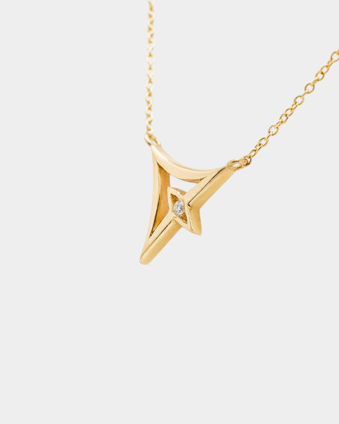 Gold necklace with a geometric pendant on a white background