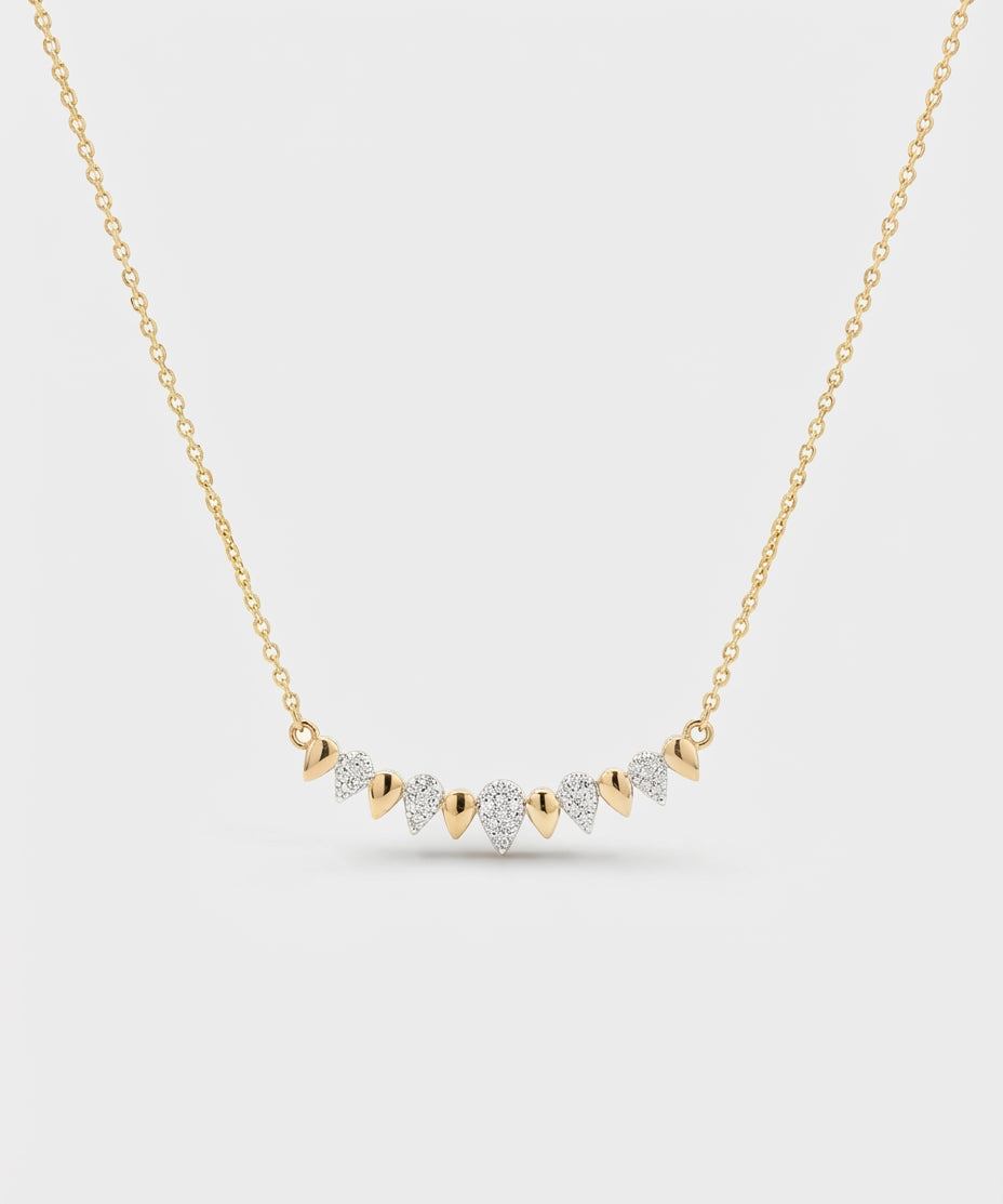 Gold necklace with diamond pendants on a light gray background