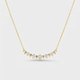 Gold necklace with diamond pendants on a light gray background