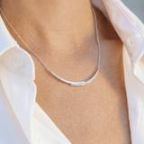 white gold with diamond smile necklace worn by a person with a white shirt