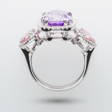 Elegant ring with a purple gemstone and pink accents on a light gray background