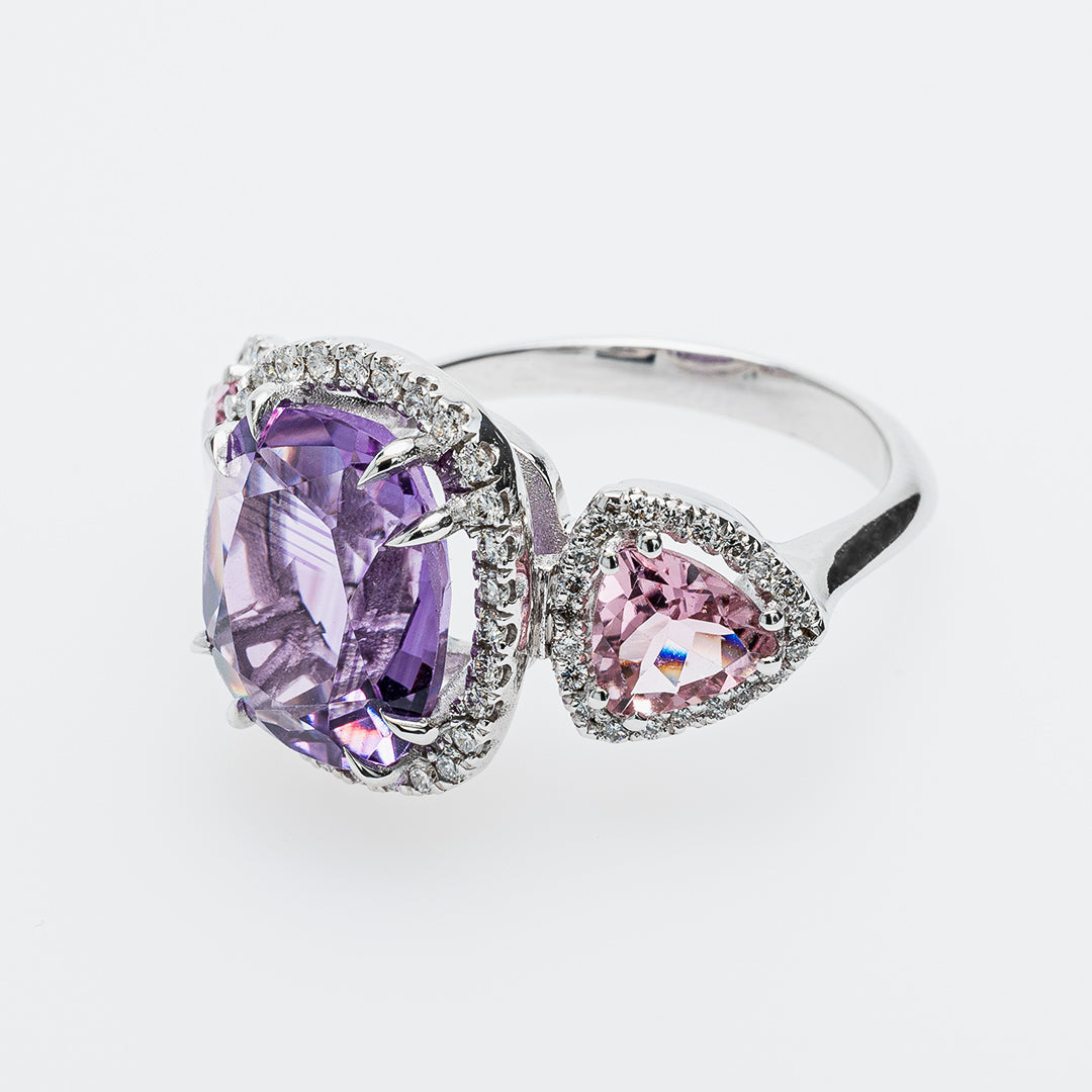 White gold ring with purple and pink gemstones on a white background