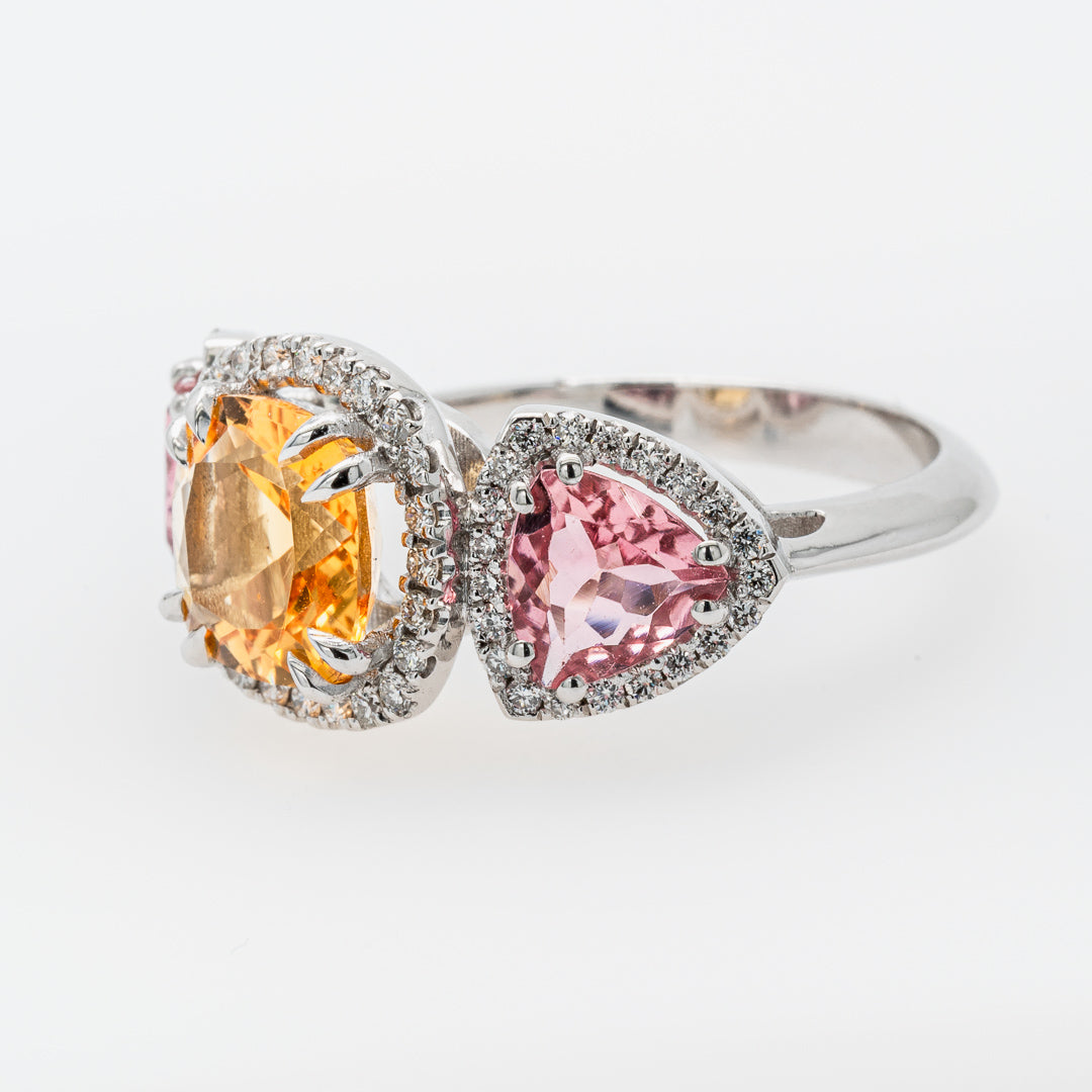 A ring with colorful tourmaline and citrine gemstones on a white background