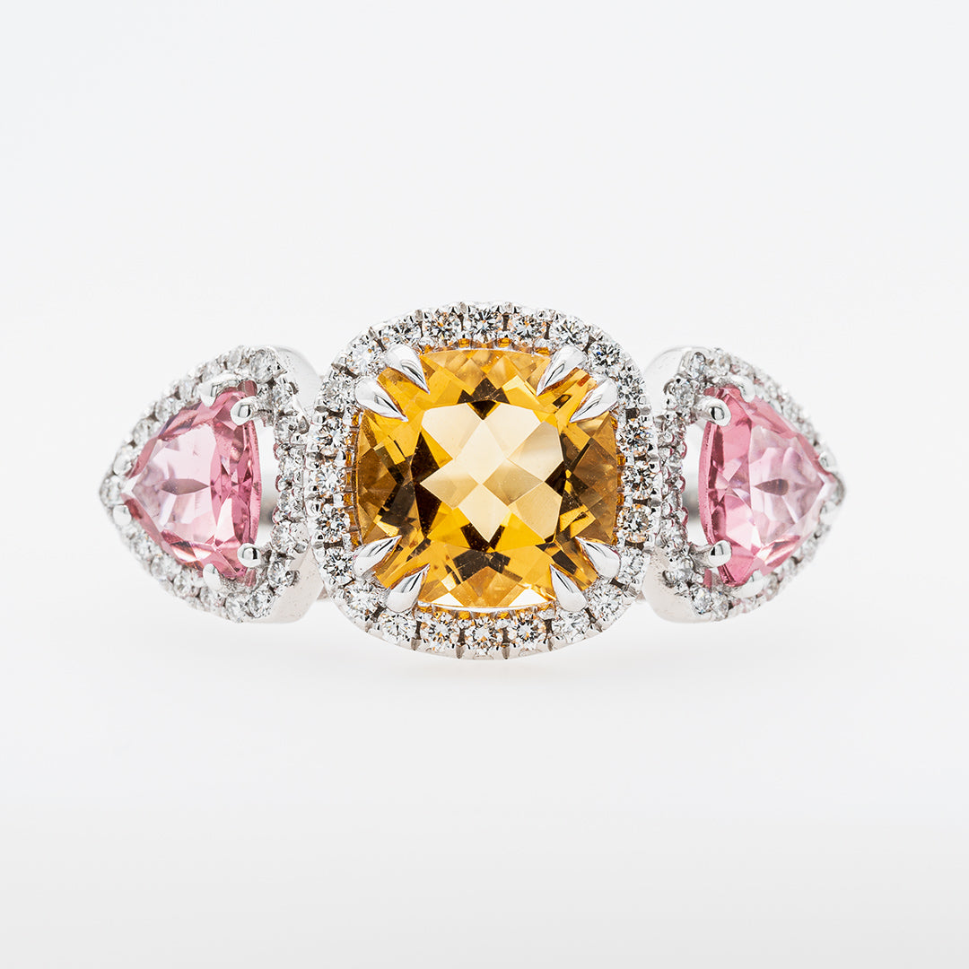 Three gemstones in a ring with tourmaline and citrine stones on a white background