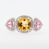 Three gemstones in a ring with tourmaline and citrine stones on a white background