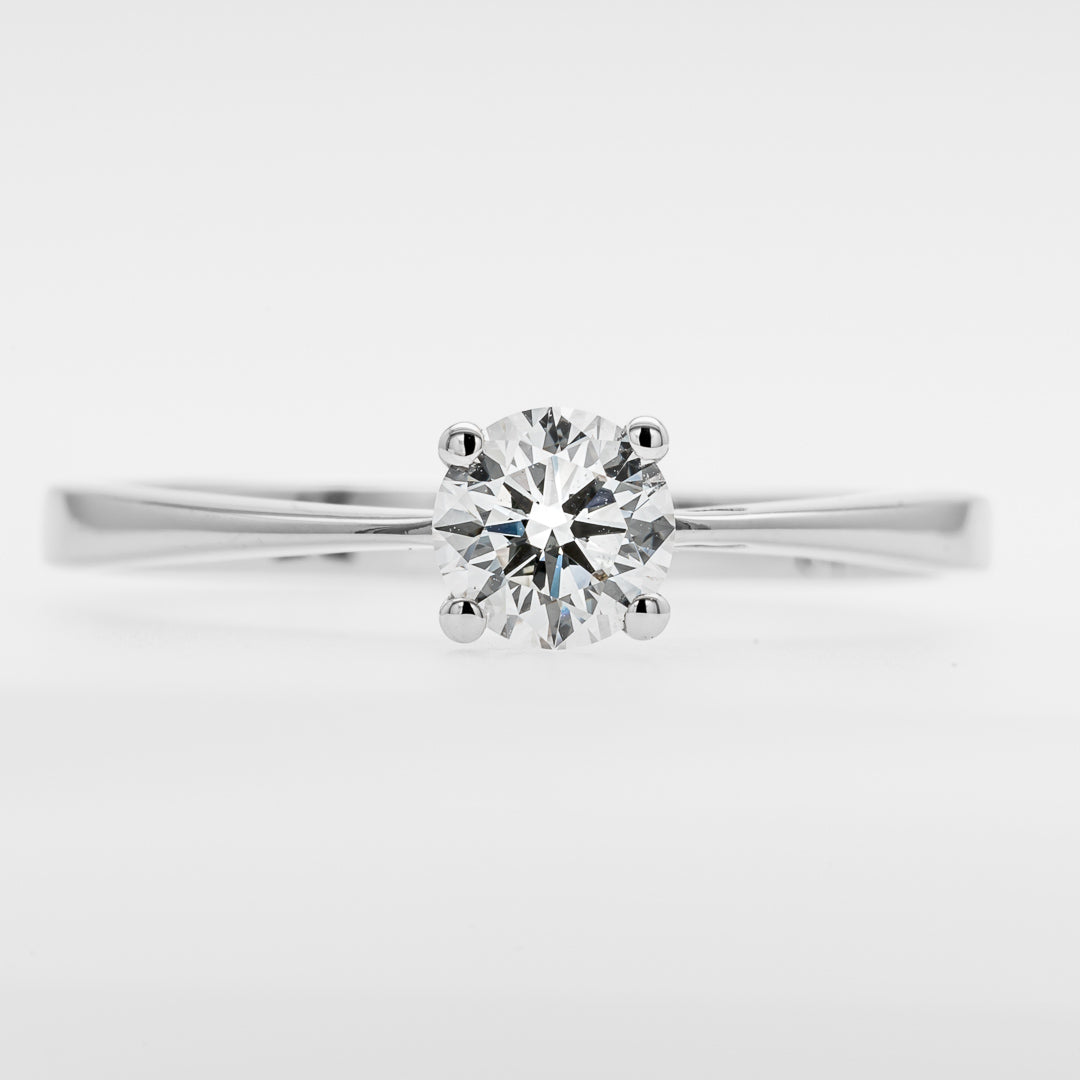 White gold ring with a diamond on a light gray background