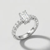 Engagement ring with an emerald-cut center diamond and pave diamond shanks