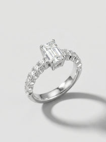 Engagement ring with an emerald-cut center diamond and pave diamond shanks