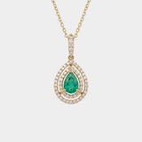 Gold necklace with a green emerald gemstone pendant on a white background