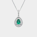 Teardrop-shaped emerald pendant with diamond accents on a white background