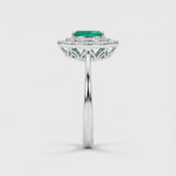 White gold ring with a green emerald gemstone on a white background