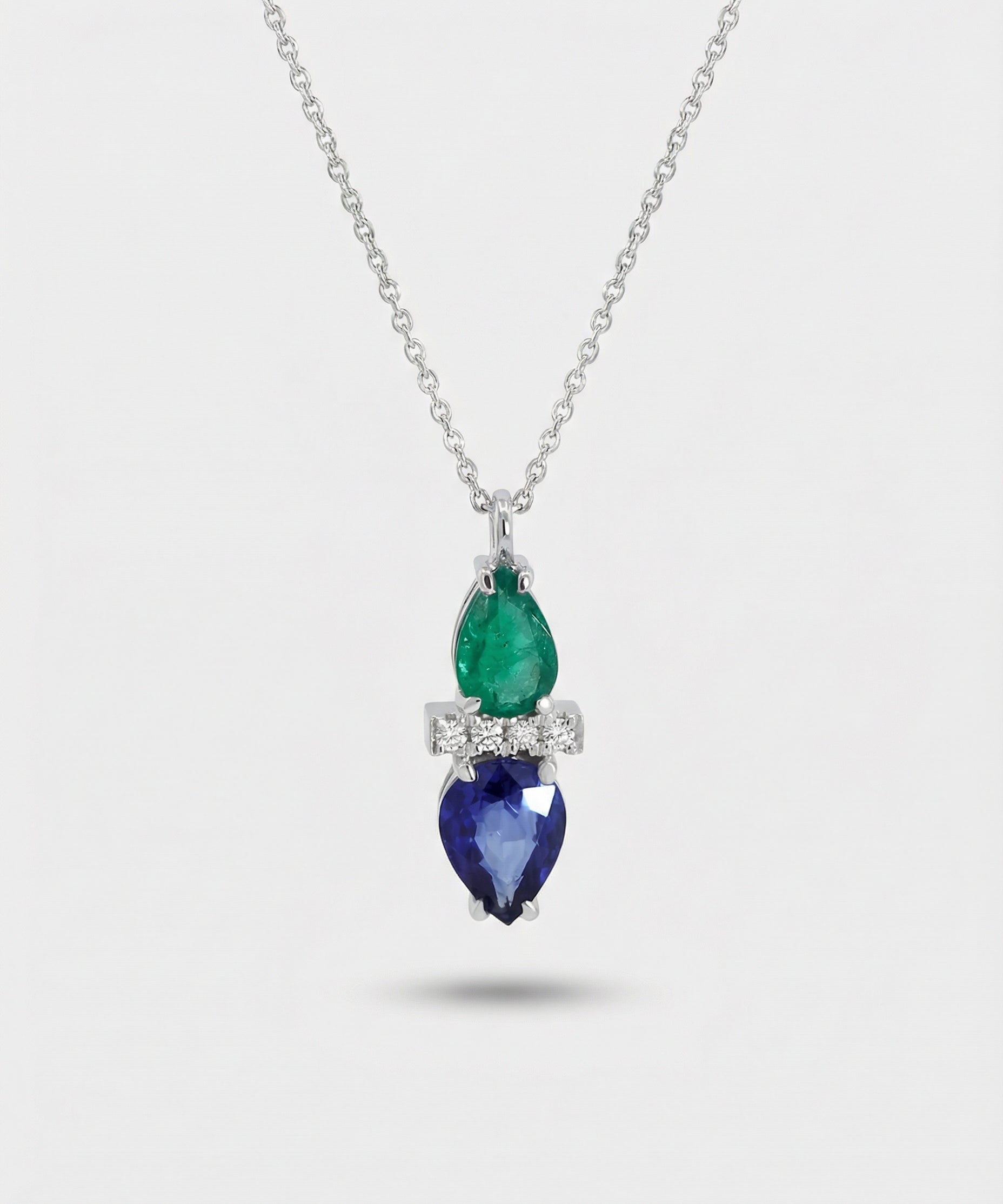 Necklace with emerald and sapphire pendant on a white background