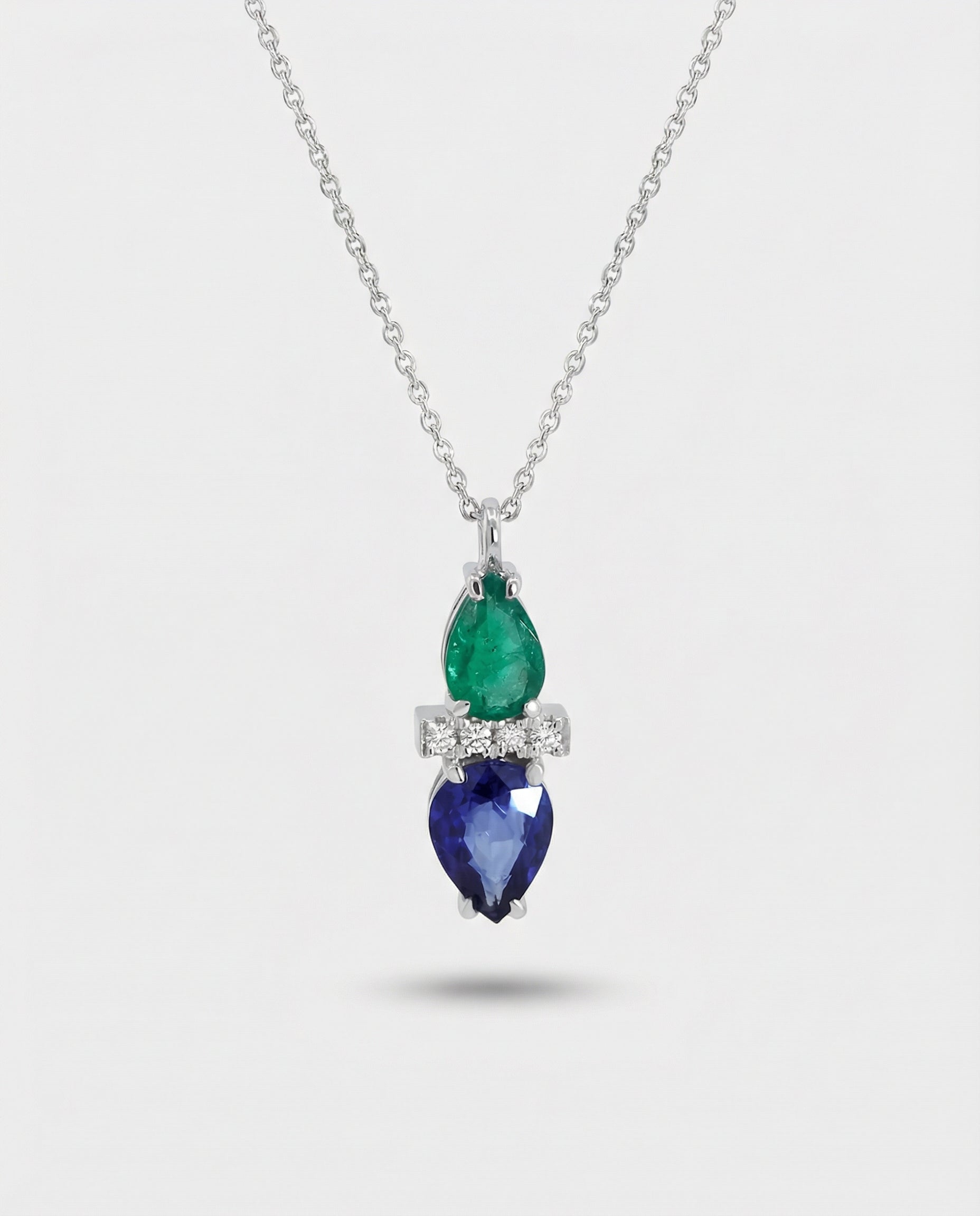 Necklace with emerald and sapphire pendant on a white background
