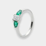 White gold ring with emeralds and diamonds on a white background