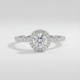 Diamond ring with a halo setting on a light gray background