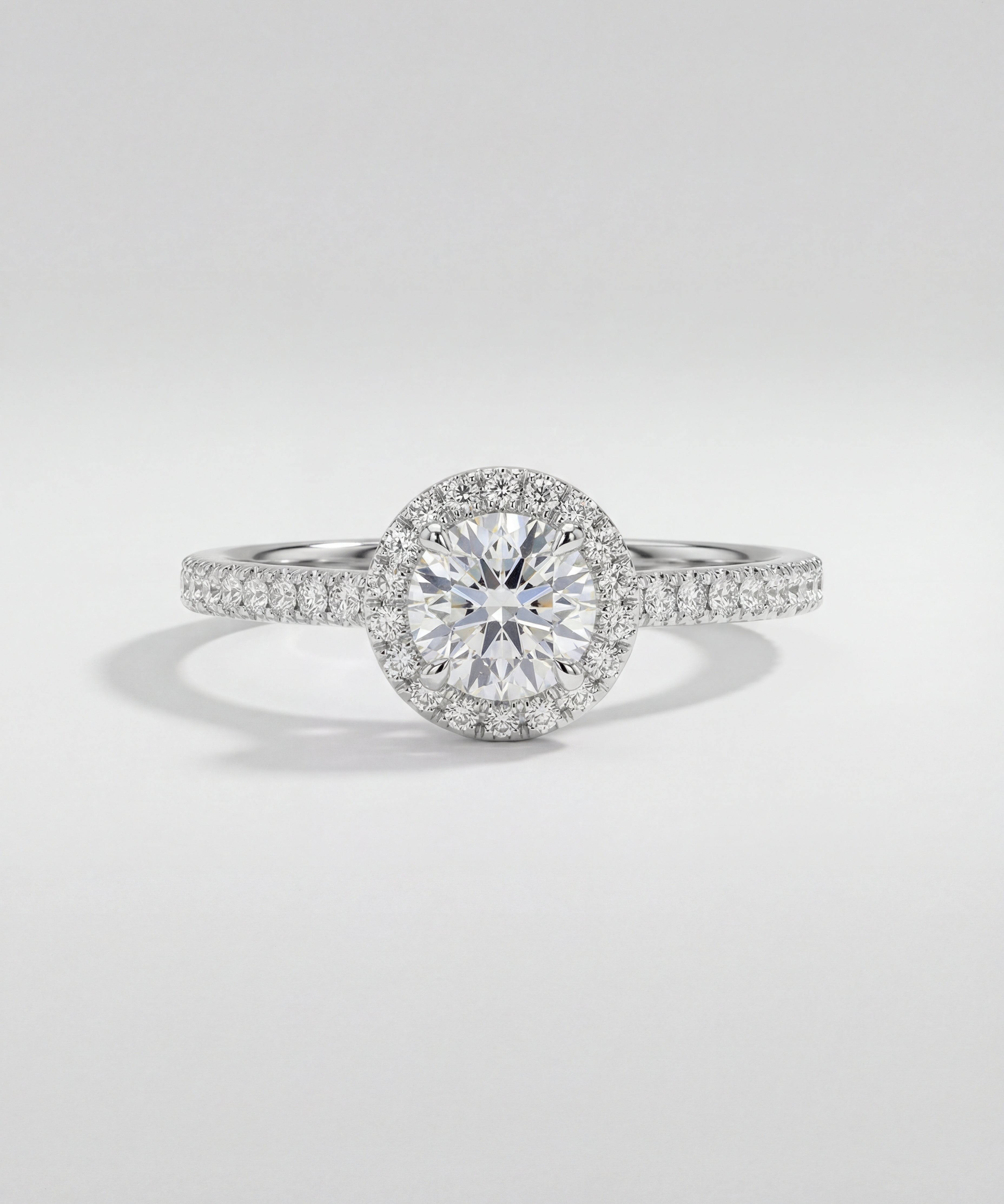 Diamond ring with a halo setting on a light gray background