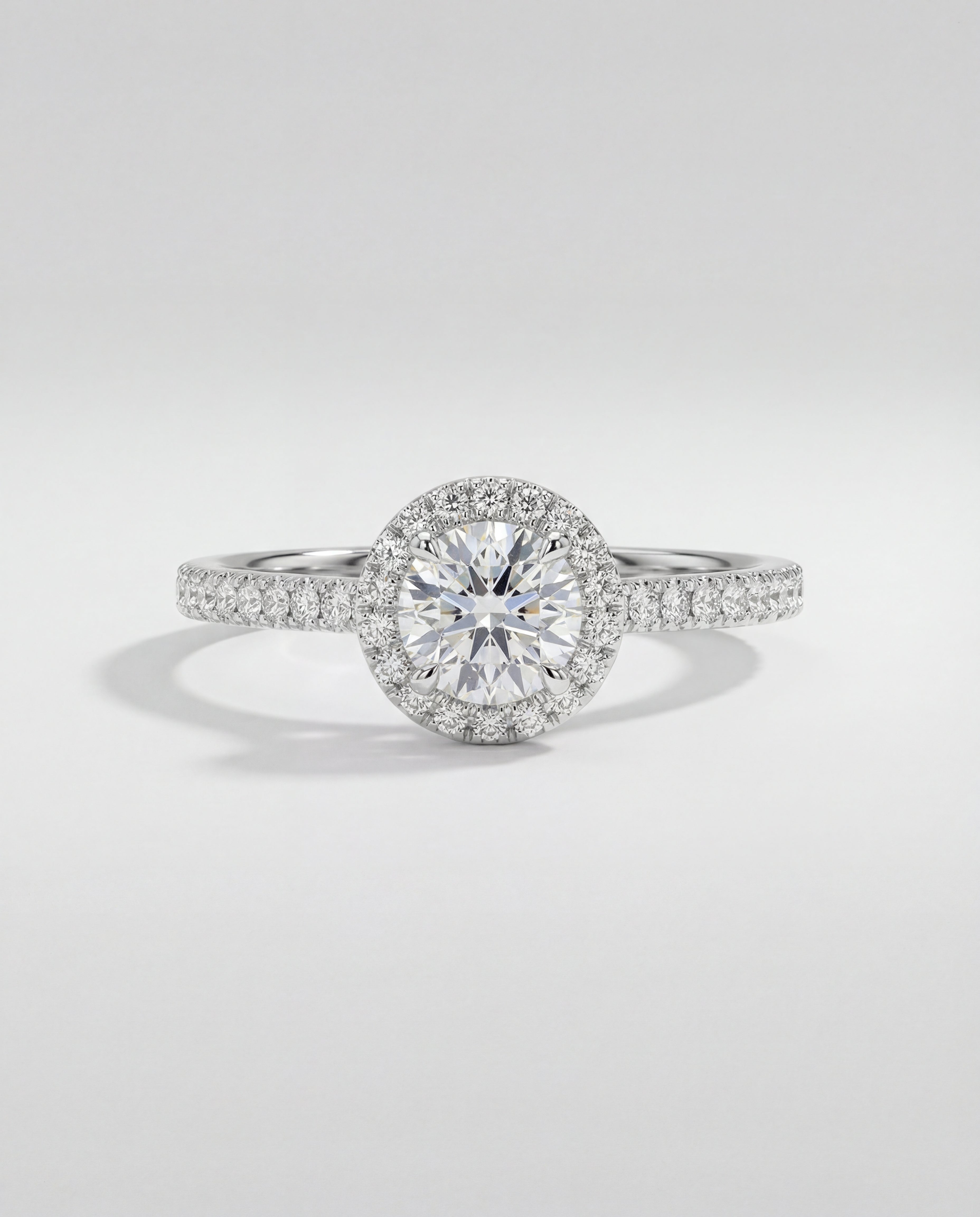 Diamond ring with a halo setting on a light gray background
