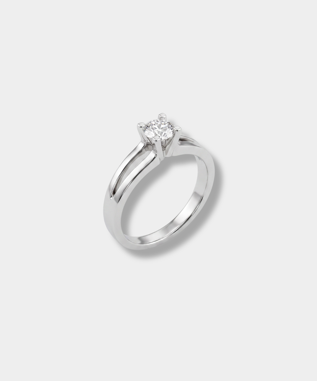 A white-gold solitaire engagement ring with a round-cut diamond, set on a clean light gray background.