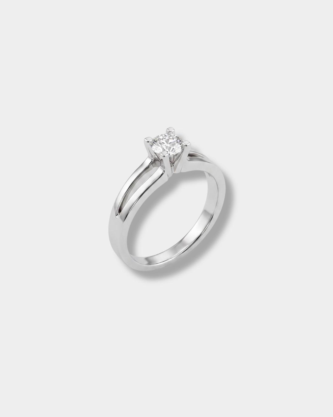 A white-gold solitaire engagement ring with a round-cut diamond, set on a clean light gray background.