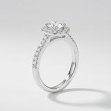 Diamond ring with a halo setting on a light gray background
