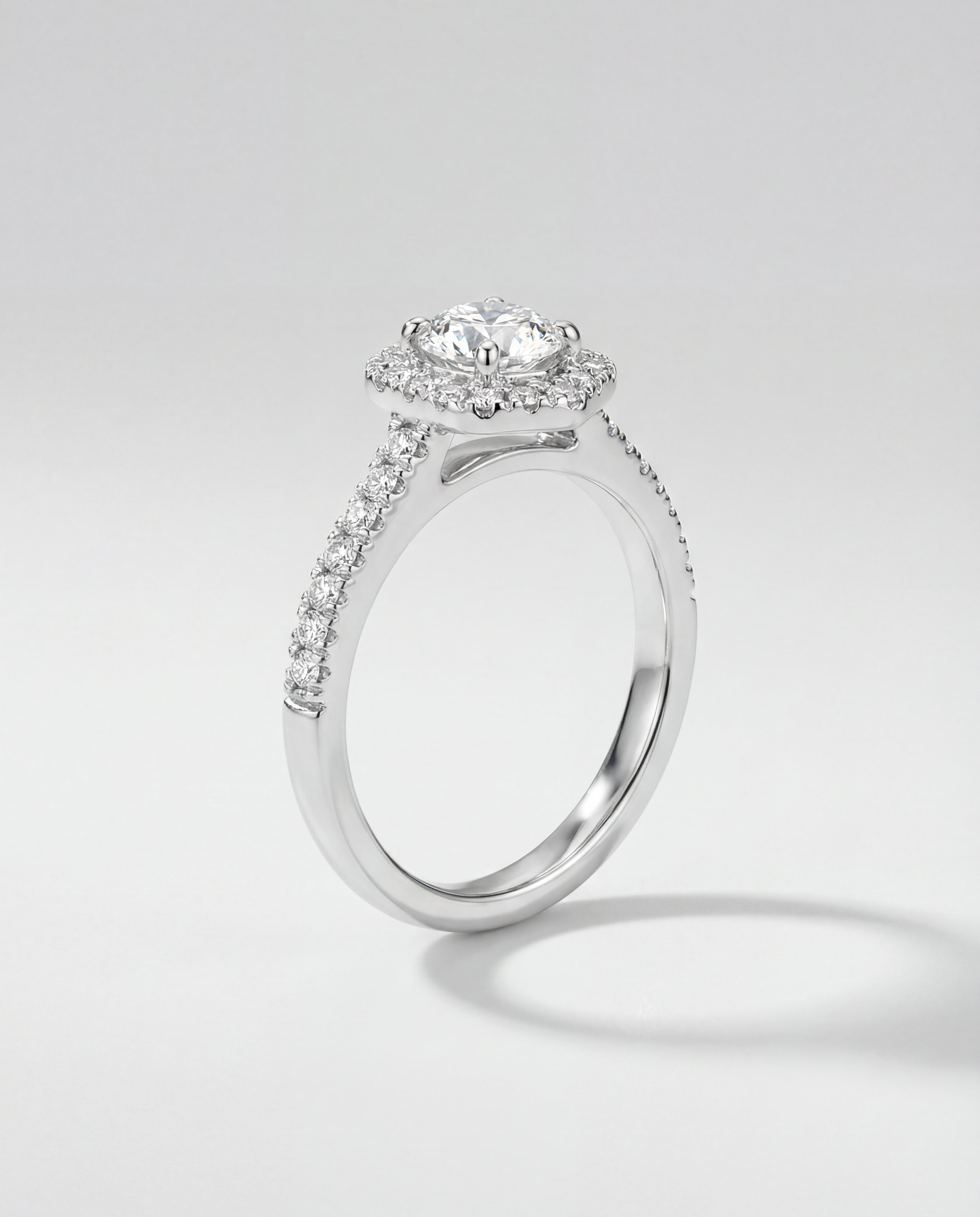 Diamond ring with a halo setting on a light gray background