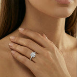 Close-up of a hand wearing a diamond ring with a blurred background