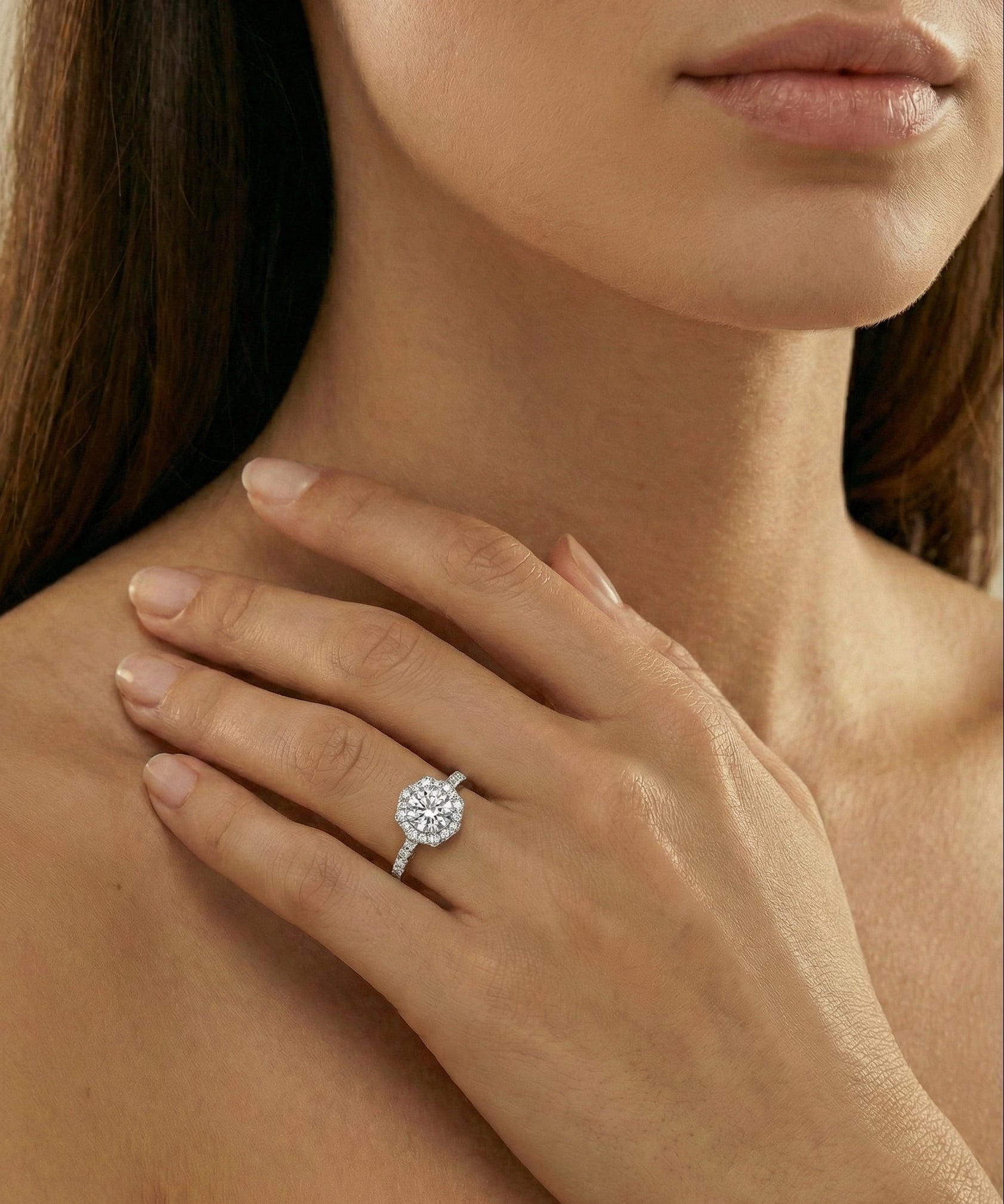 Close-up of a hand wearing a diamond ring with a blurred background