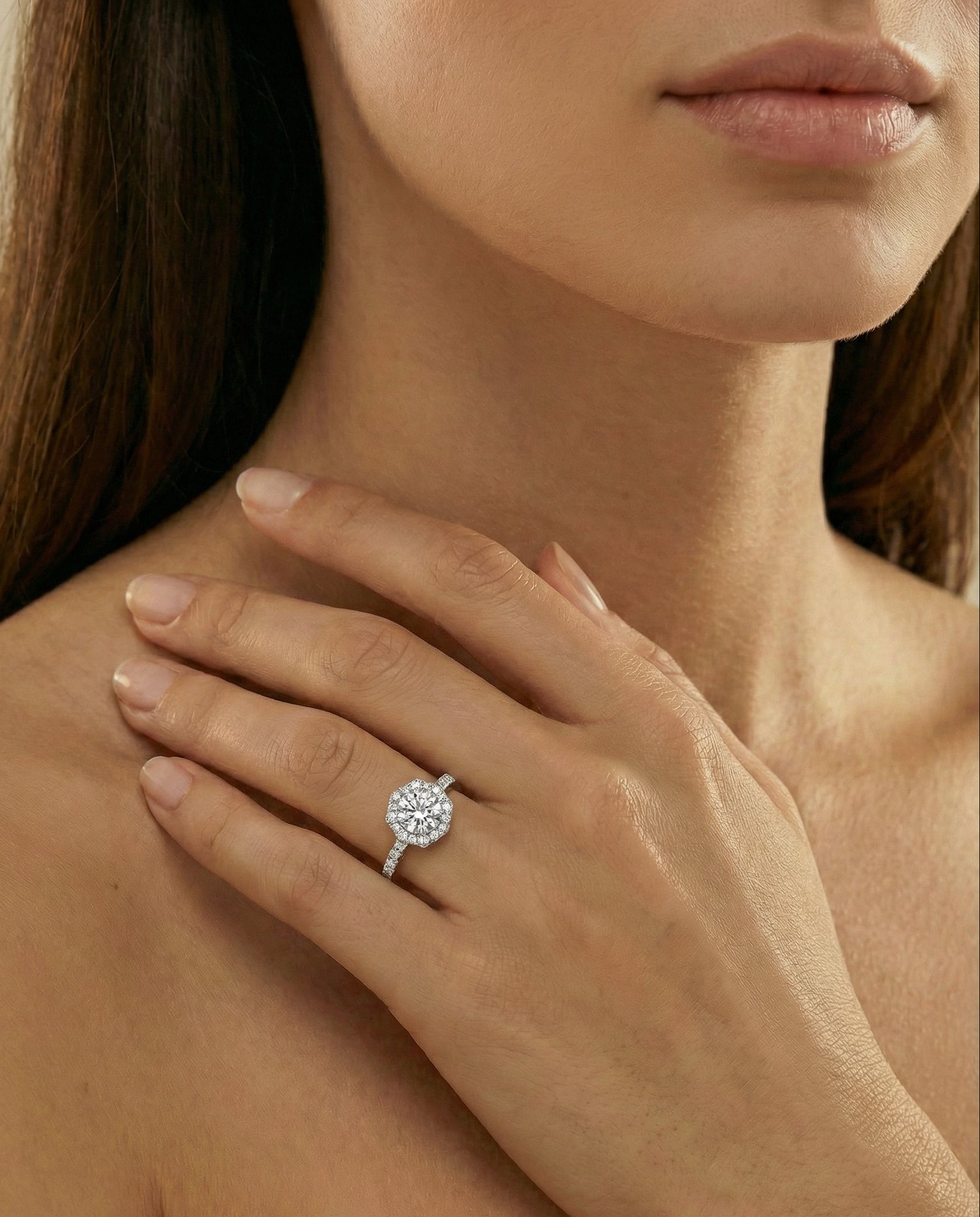 Close-up of a hand wearing a diamond ring with a blurred background