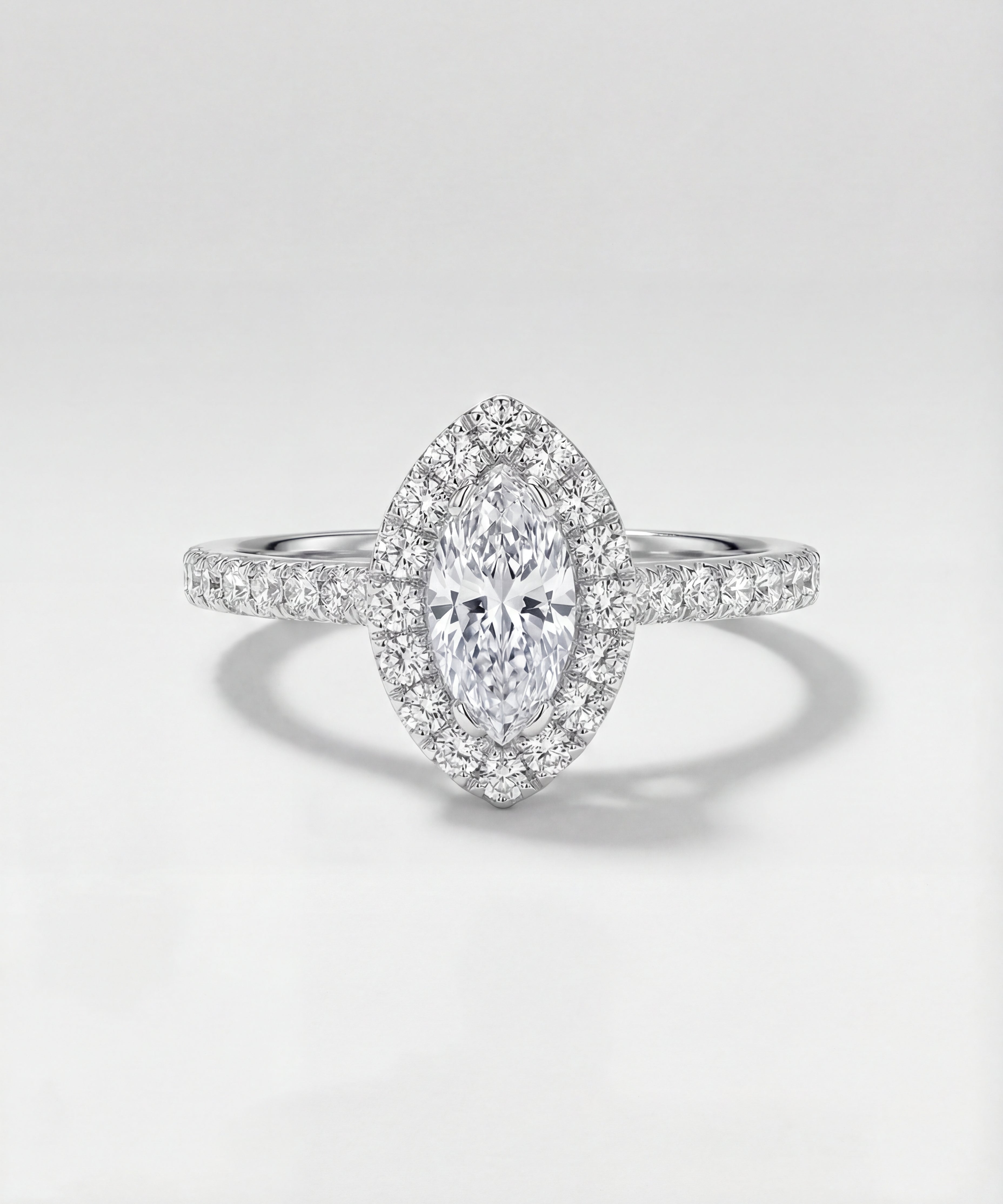 Diamond ring with a marquise-shaped center stone on a light gray background