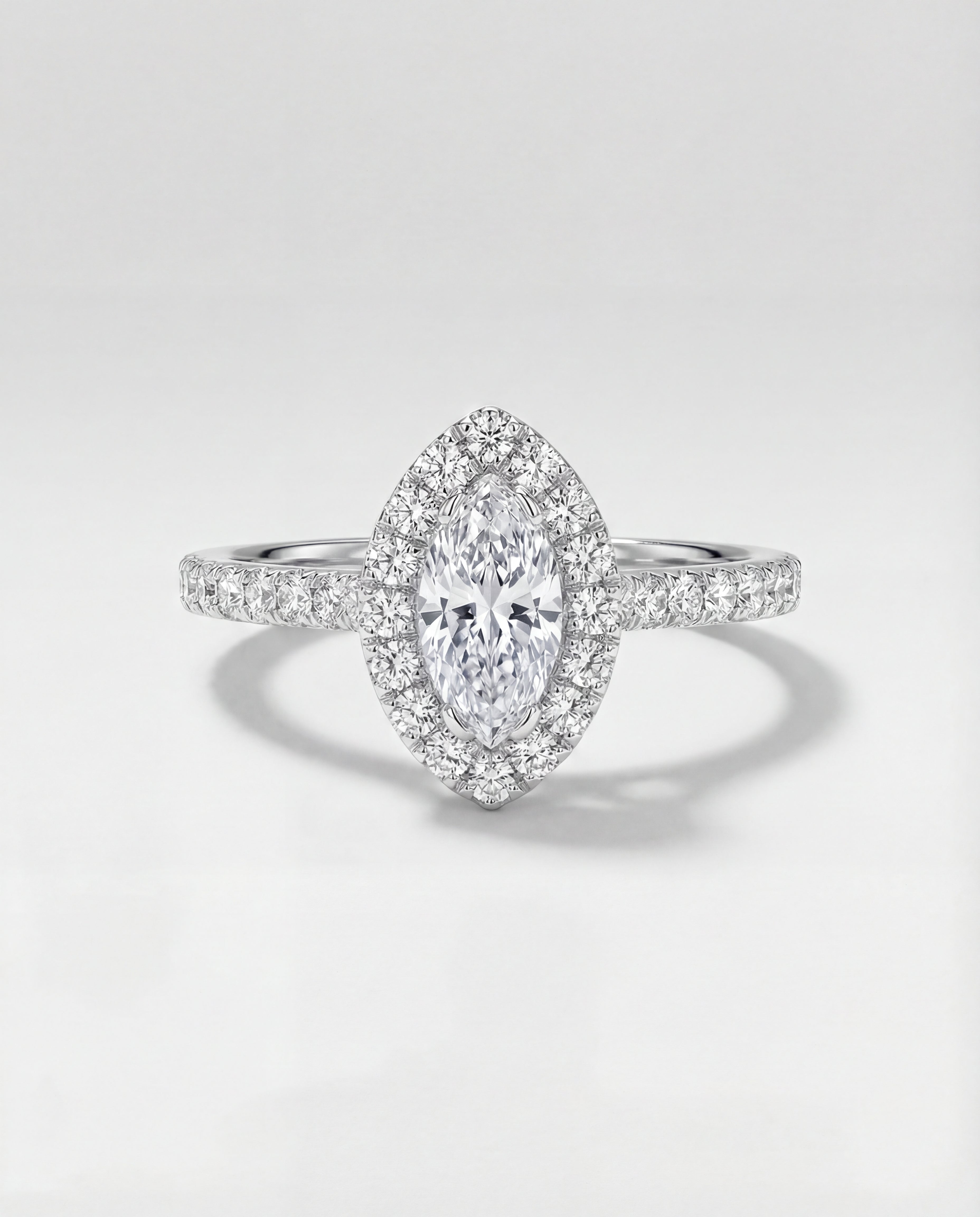 Diamond ring with a marquise-shaped center stone on a light gray background