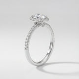 Diamond ring with a halo setting on a light gray background