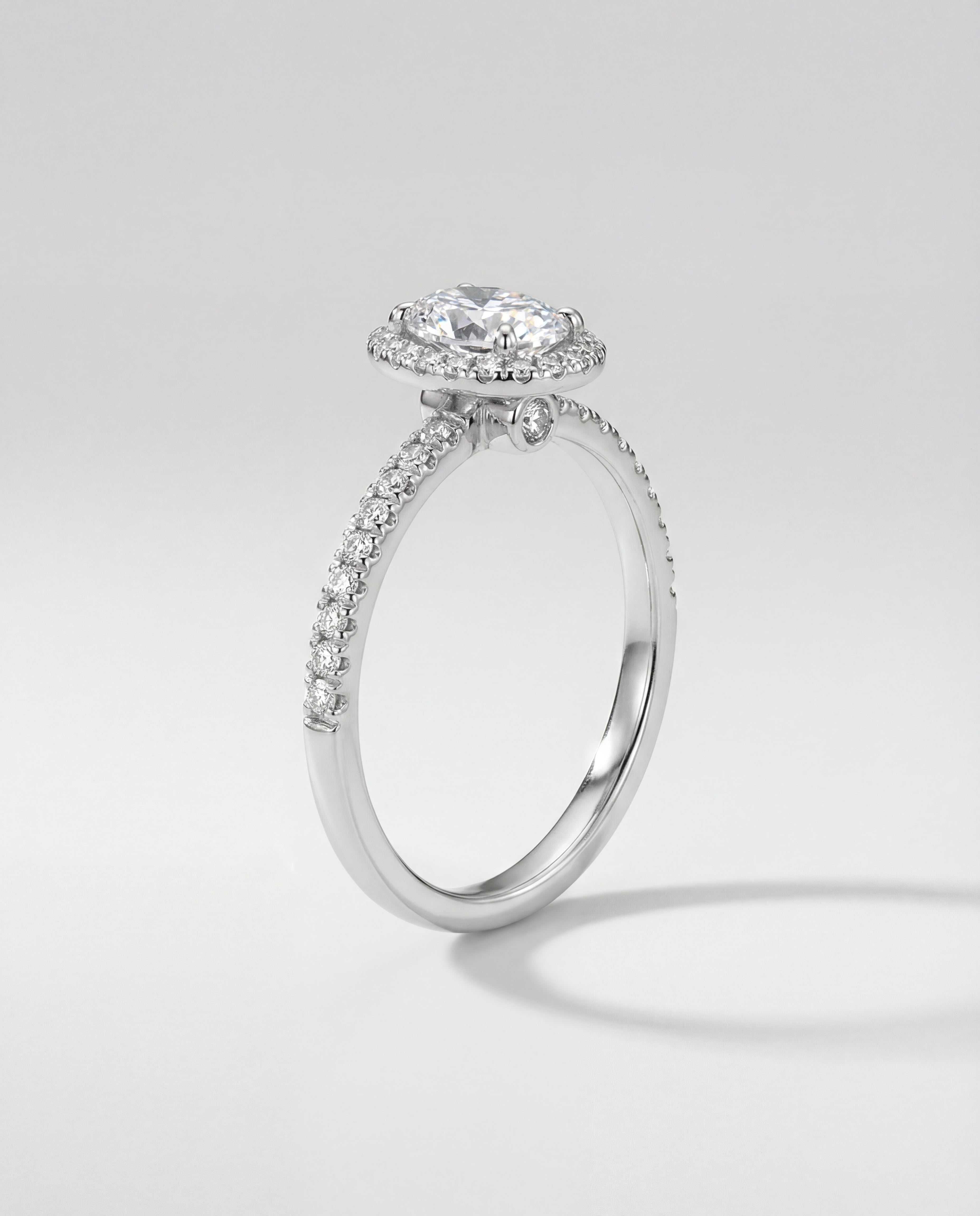 Diamond ring with a halo setting on a light gray background