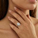 A model's hand wearing an oval-cut diamond halo engagement ring 