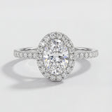 Oval-shaped diamond ring with a halo on a light gray background