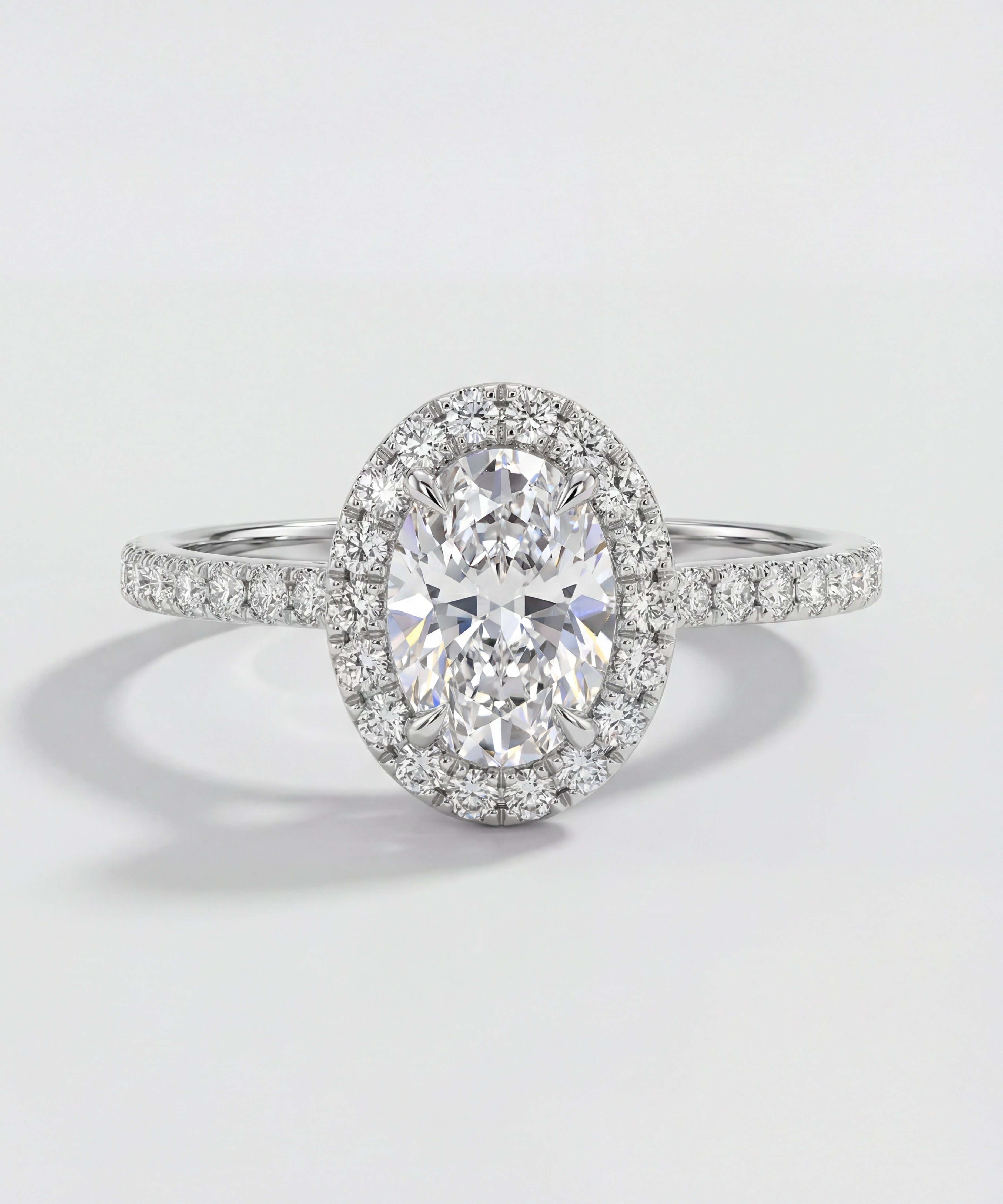 Oval-shaped diamond ring with a halo on a light gray background
