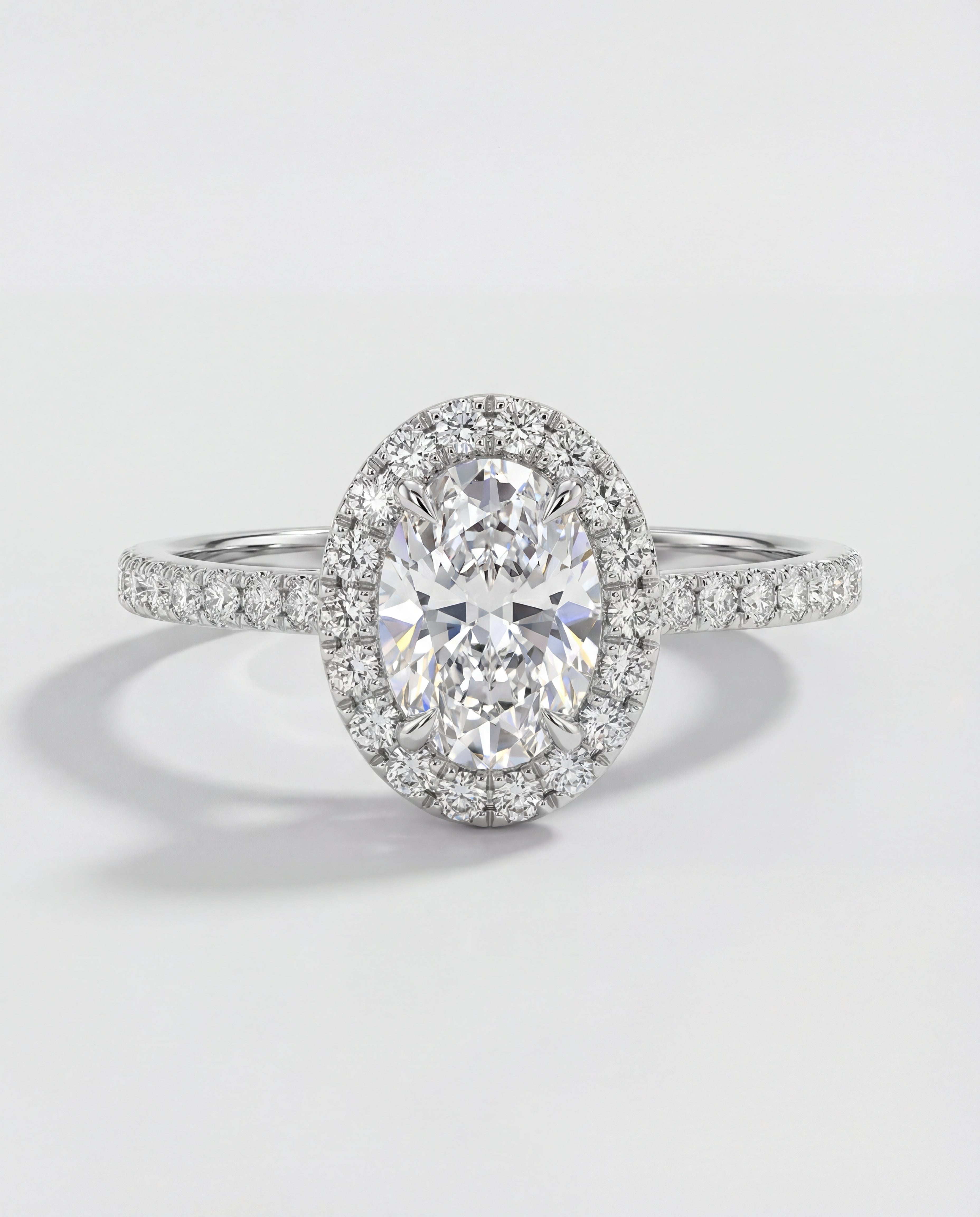 Oval-shaped diamond ring with a halo on a light gray background