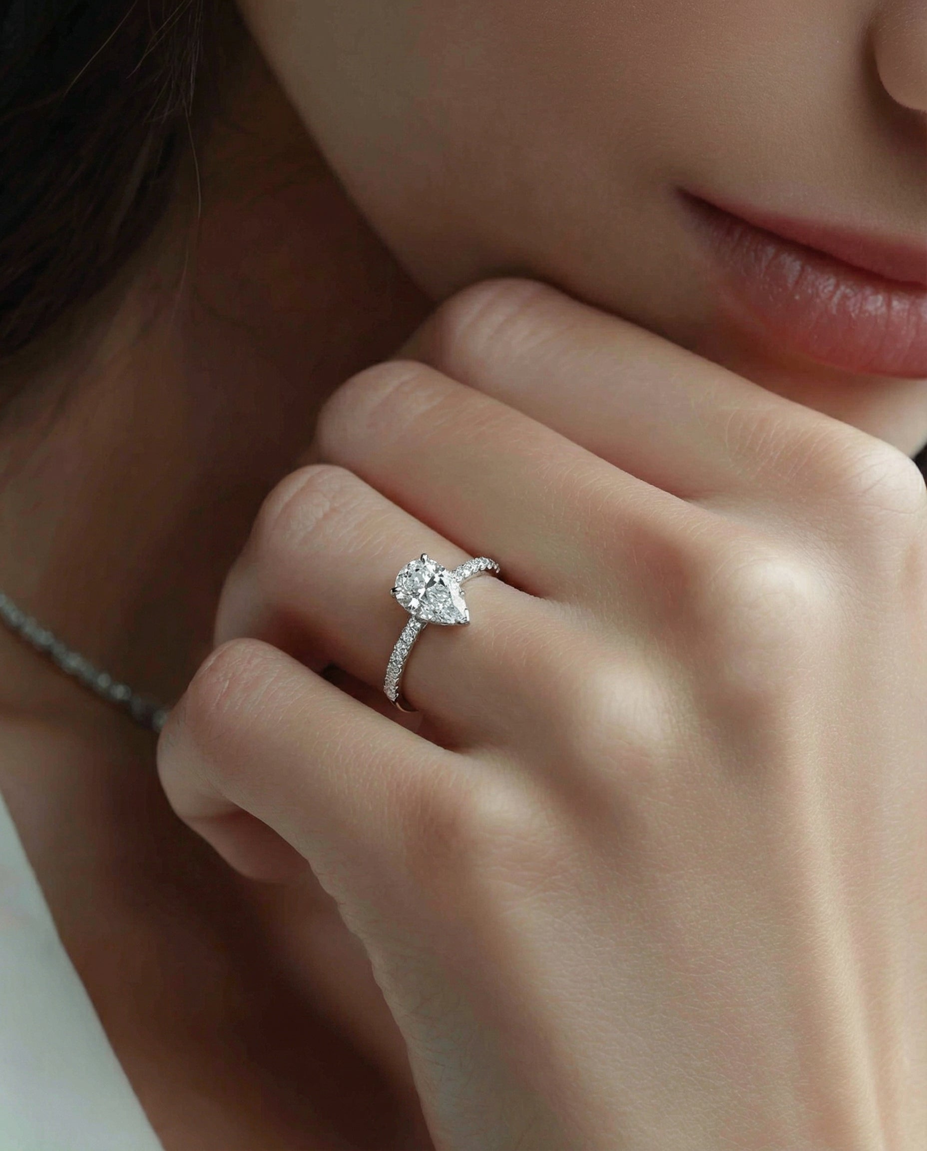 Close-up of a hand wearing a diamond ring with a blurred background