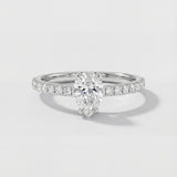 An engagement ring with a pear-cut center diamond