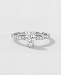 An engagement ring with a pear-cut center diamond
