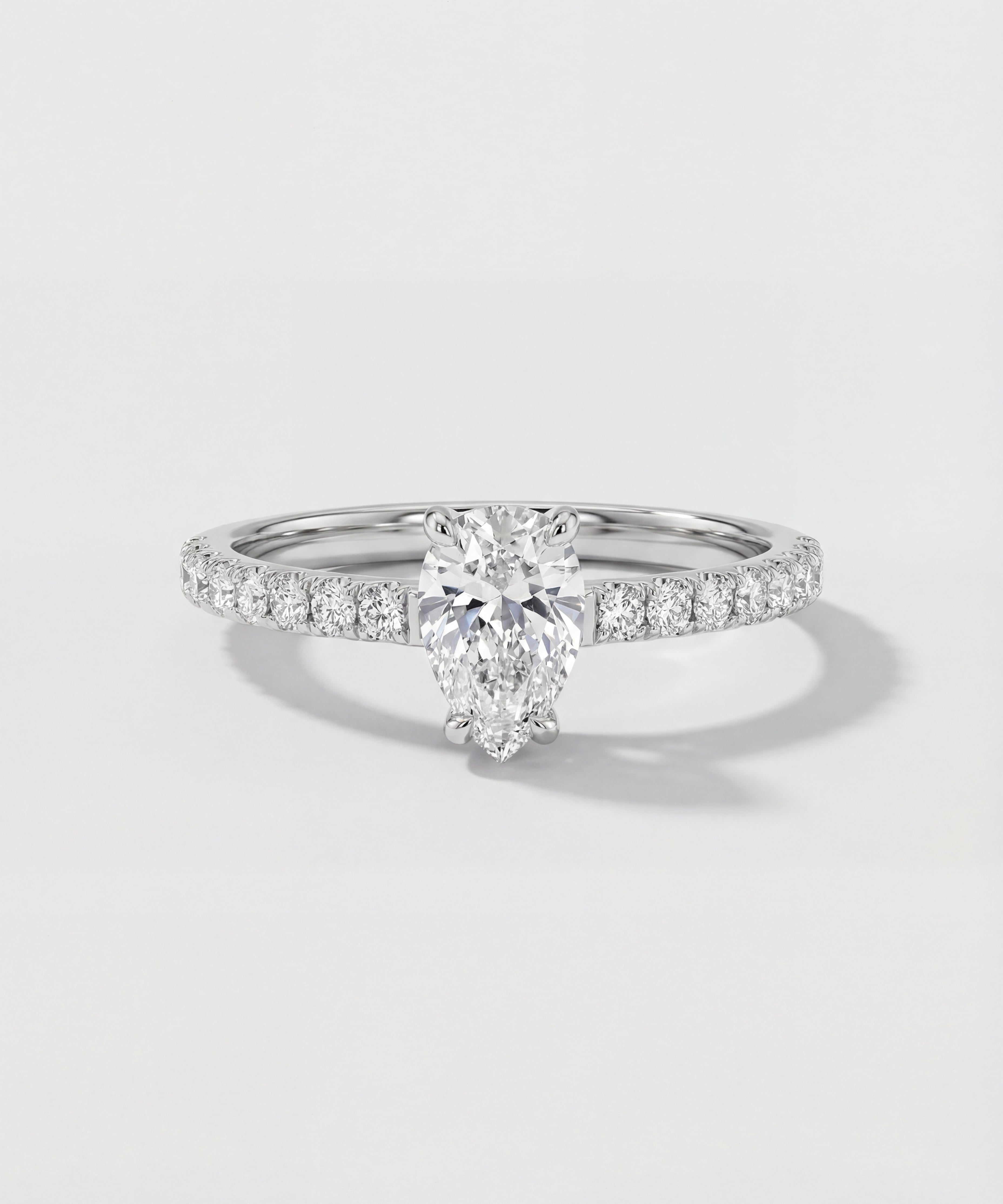 An engagement ring with a pear-cut center diamond