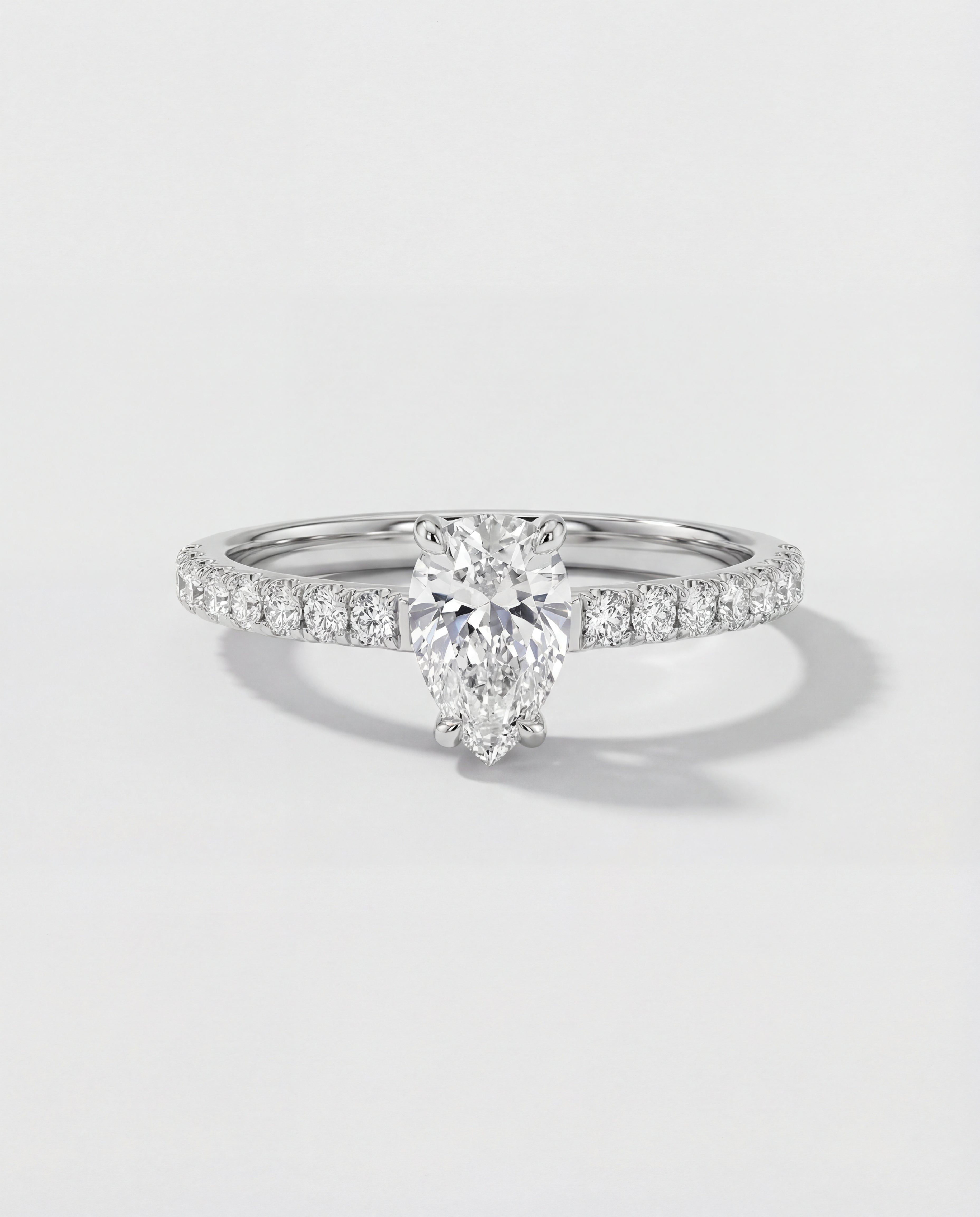 An engagement ring with a pear-cut center diamond