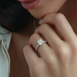 Close-up of a hand wearing a diamond ring with a soft focus background