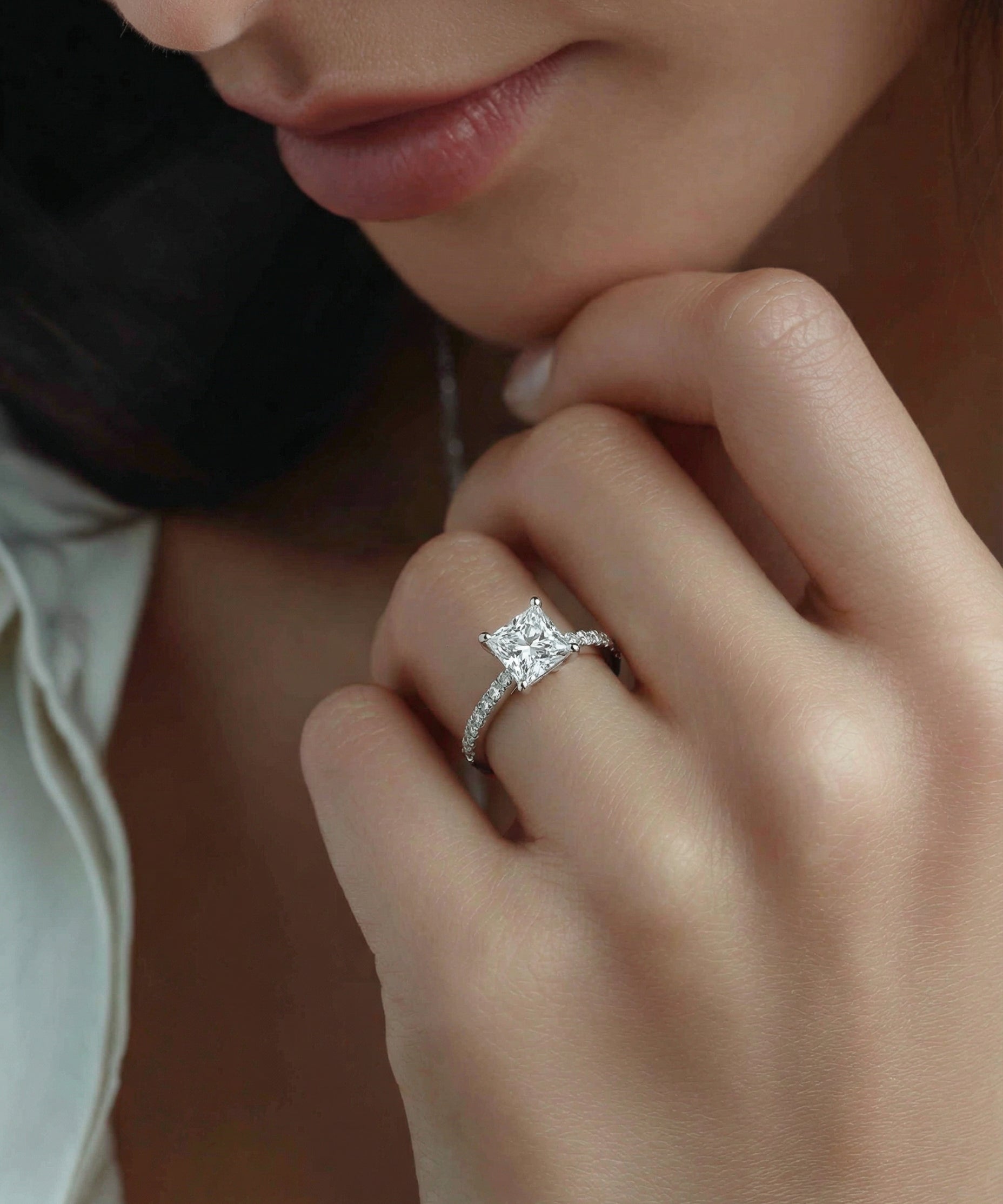 Close-up of a hand wearing a diamond ring with a soft focus background