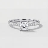 Diamond ring with a square-cut center stone on a light gray background