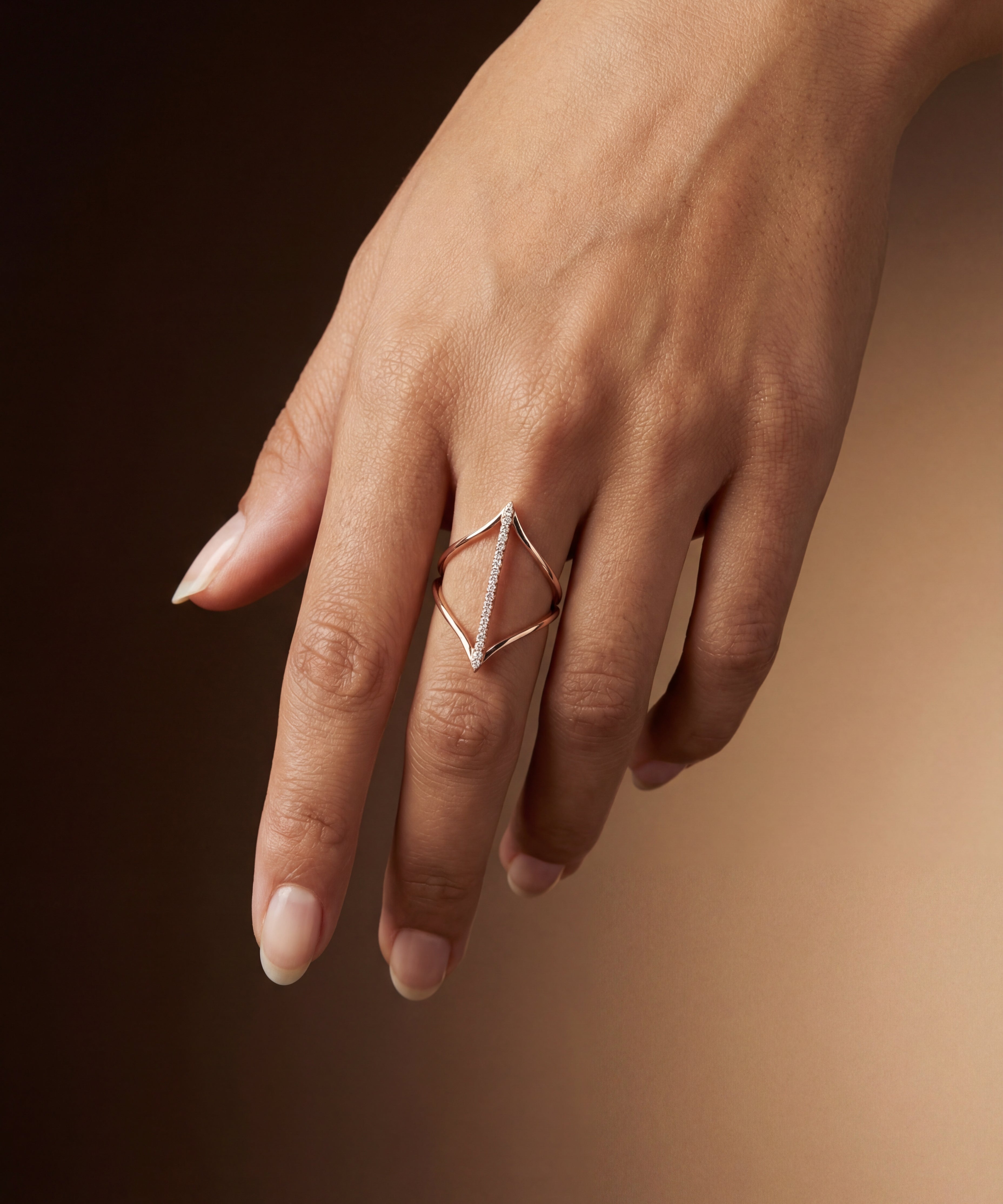 Hand wearing a geometric ring on a dark background