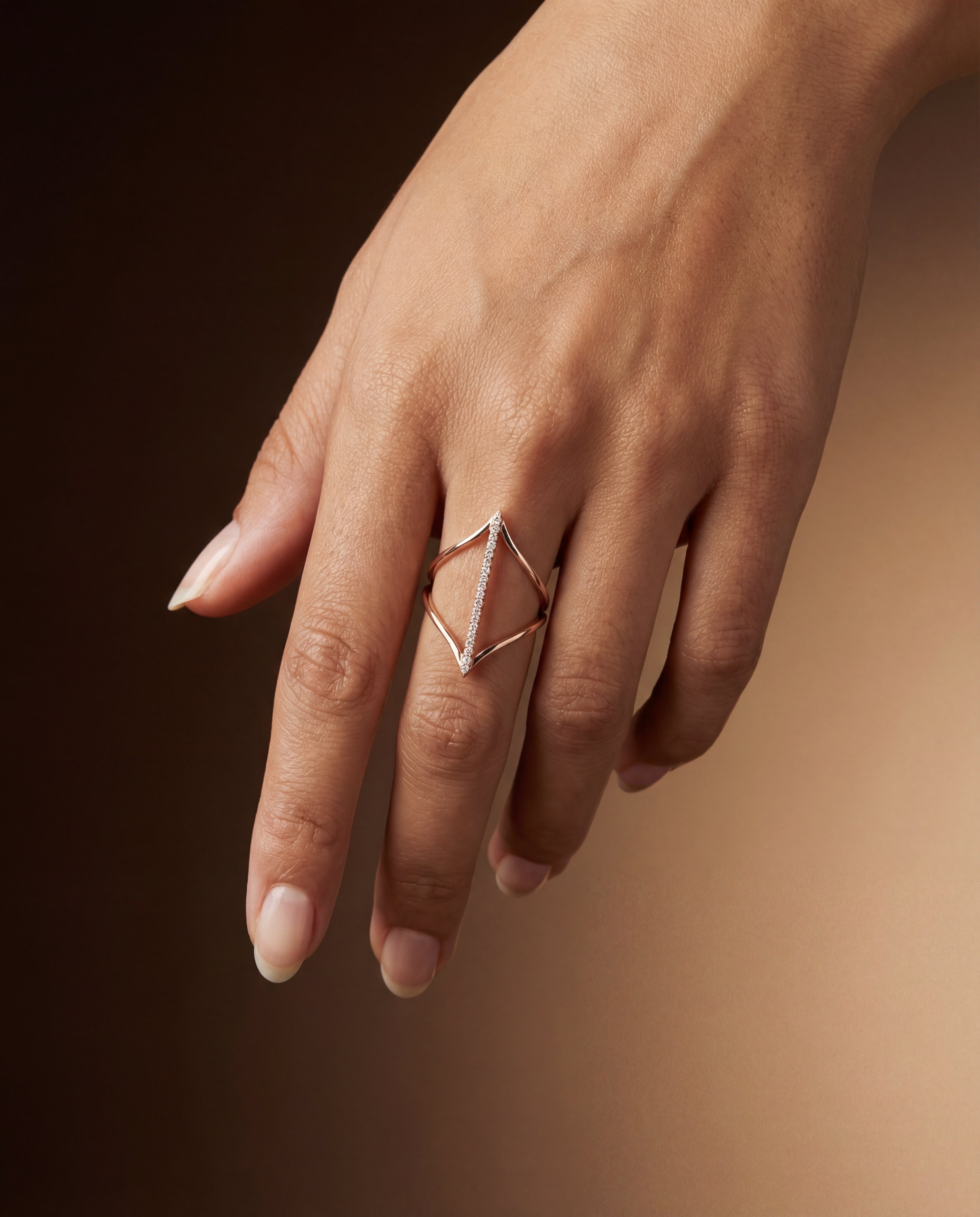 Hand wearing a geometric ring on a dark background