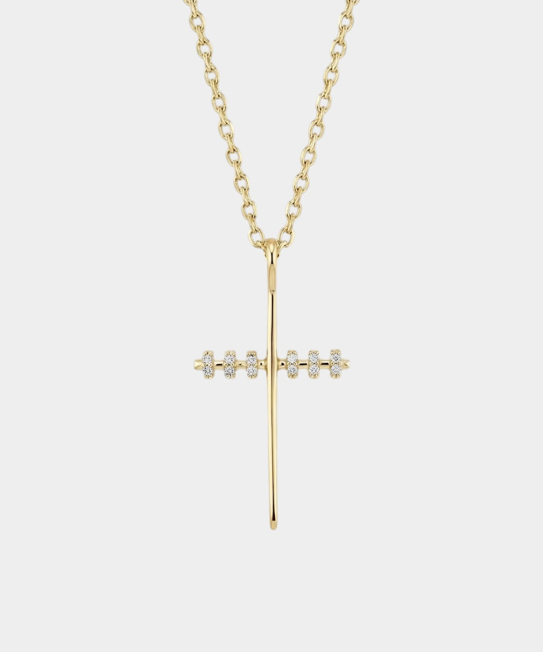Gold cross necklace with diamonds on a white background