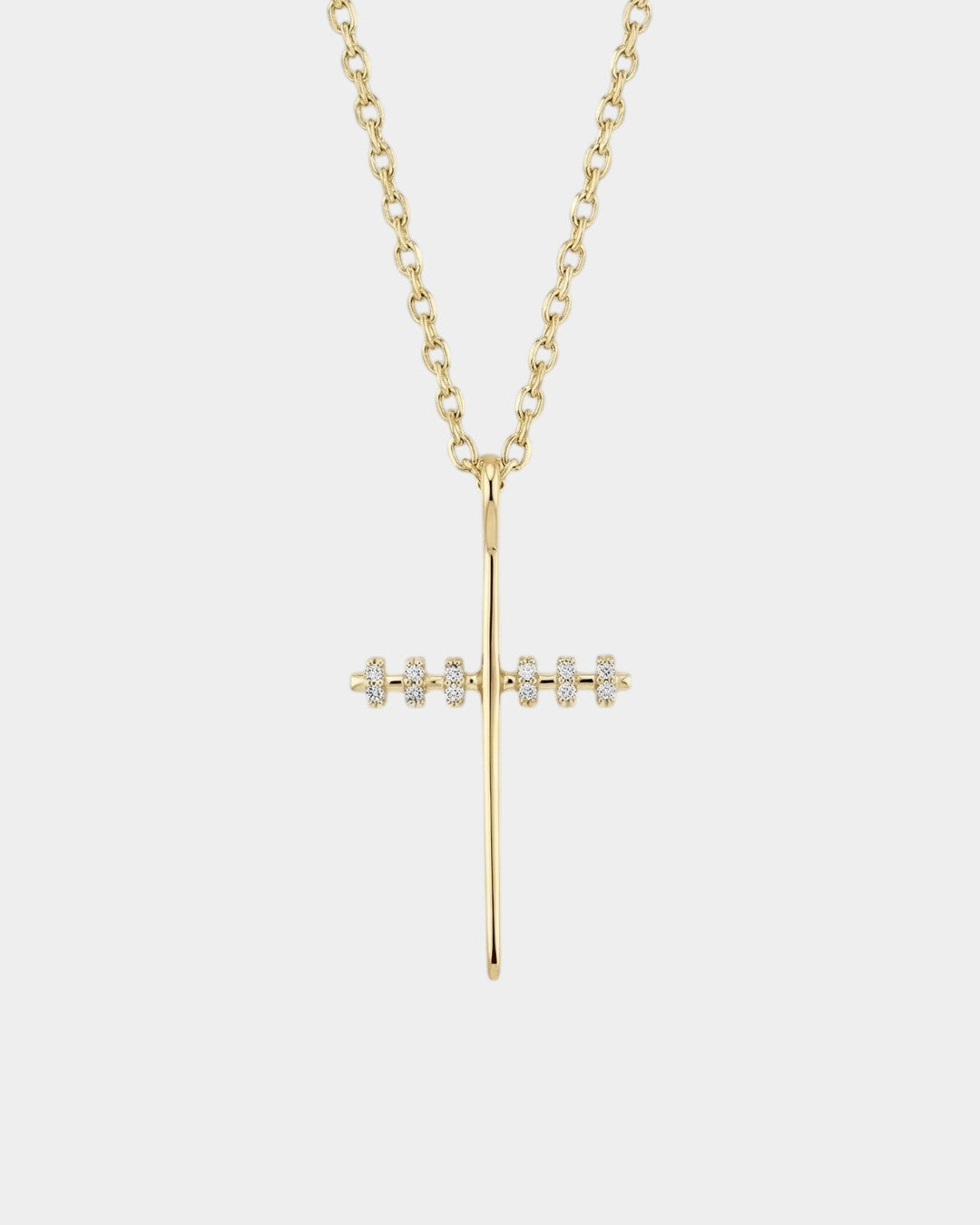 Gold cross necklace with diamonds on a white background